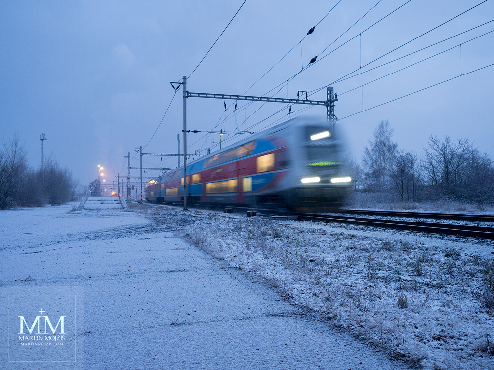 A passenger train departs from a snowy station on a frosty winter morning. Photograph created with the Olympus 12 - 40 mm 2.8 Pro lens.